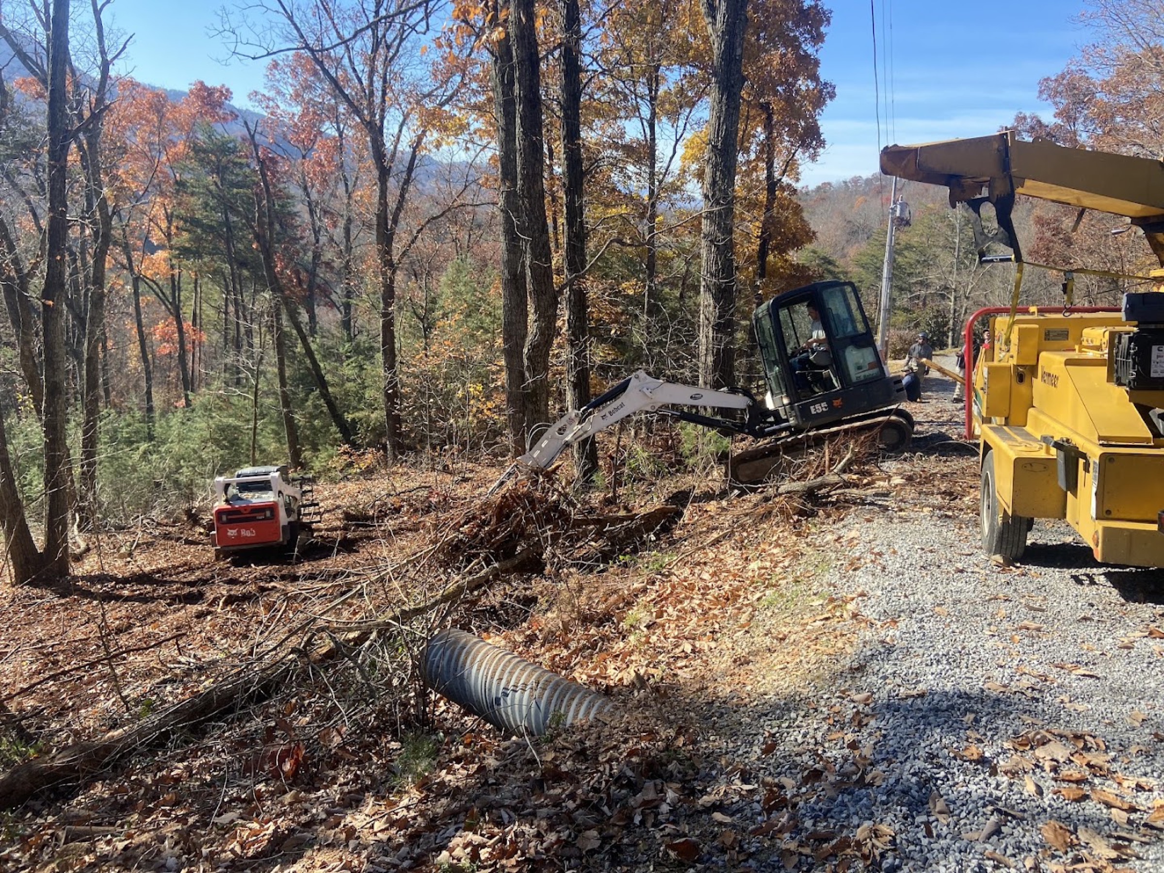 Elite Tree Service clearing land at golden hour with the Tennessee mountains behind