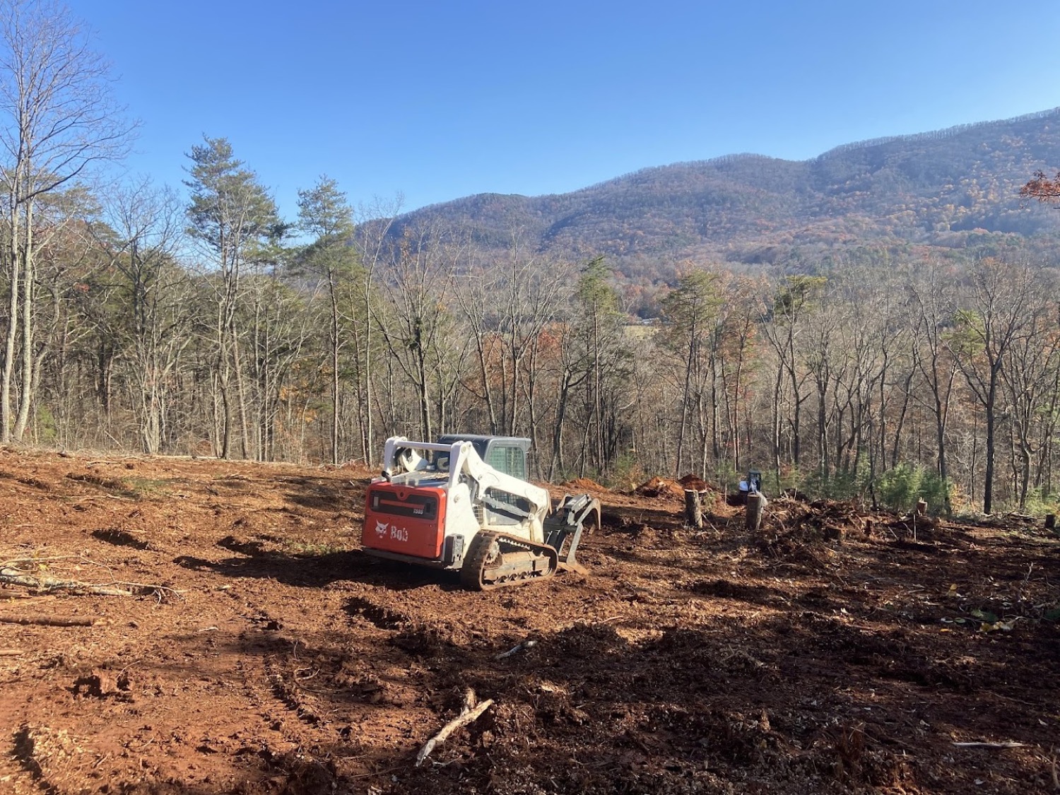 A hillside lot cleared by Elite Tree Service with the Tennessee mountains behind